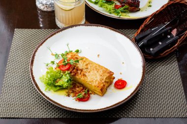 Lezzetli ızgara somon, sebzeli ve peynirli beyaz tabak.