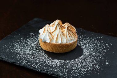 Kremalı çikolatalı kek ve siyah arkaplanlı nane.