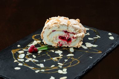 Koyu arkaplanda kremalı ve dutlu lezzetli pasta.