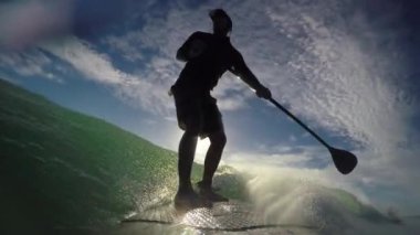 Standup paddle board surfing early morning at Waihi beach, New Zealand