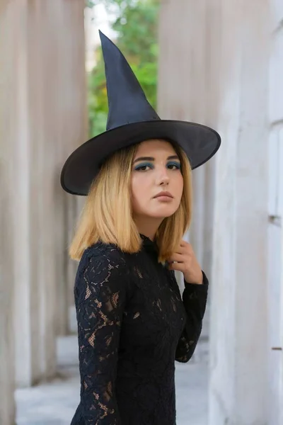 Joven bruja en vestido negro y la tapa de Halloween todos los santos día libre espacio para el texto —  Fotos de Stock