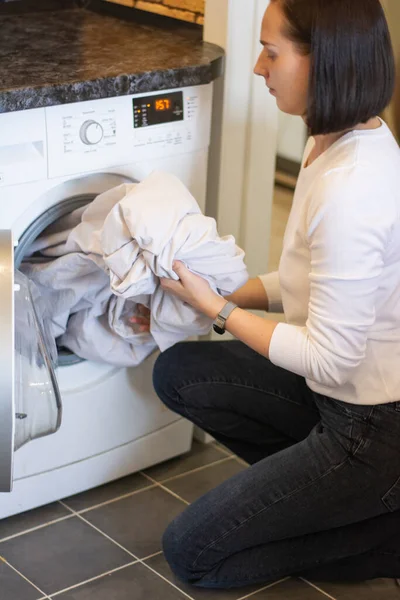 Foto de cerca de las manos femeninas sacando ropa blanca limpia de la lavadora — Foto de Stock
