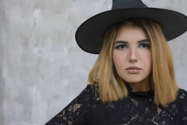 Joyeux gothique jeune femme en costume de sorcière Halloween avec chapeau sur fond gris — Photo