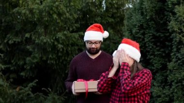Noel ve yeni yıl kutlamaları için sevgilisine Noel hediyesi veren bir adam.