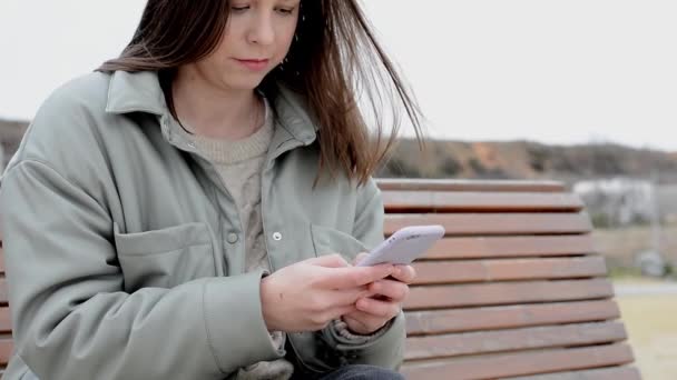 Primo piano delle mani femminili in strada scrive messaggi sul suo telefono — Video Stock