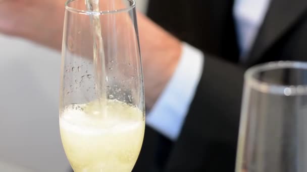 Vista lateral de cerca del vino espumoso o burbujas de champán que se vierten en una copa de champán — Vídeo de stock