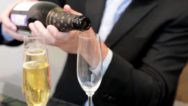 Close up side view of pouring sparkling wine or champagne into glass — Video