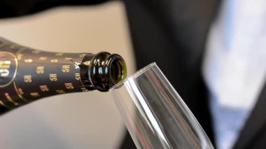 Close up side view of sparkling wine or champagne bubbles being poured into a glass of champagne