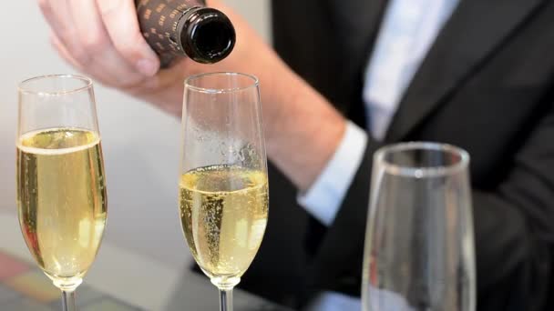 Close up side view of sparkling wine or champagne bubbles being poured into a glass of champagne — Video