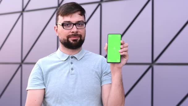 Зелений екран телефону сенсорний екран на вулиці біля будівлі чоловік використовує смартфон — стокове відео