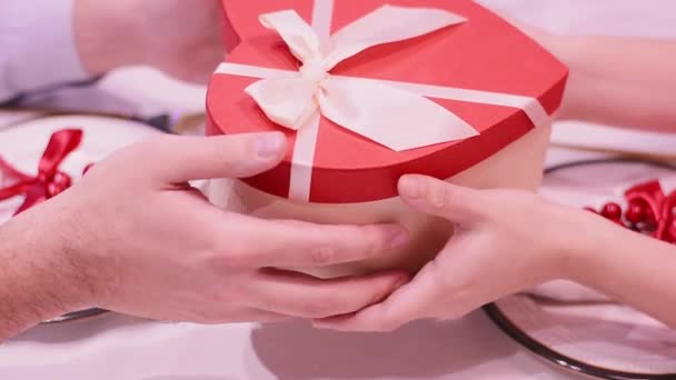 Αγαπητό ζευγάρι σε ένα αγόρι ραντεβού δίνει στη φίλη της ένα δώρο με τη μορφή καρδιάς — Αρχείο Βίντεο