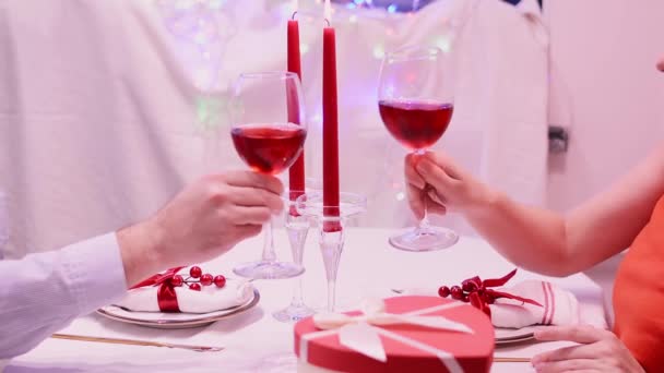 Szekrény pár koccogó pohár vörösbor pirítós romantikus vacsora étteremben — Stock videók