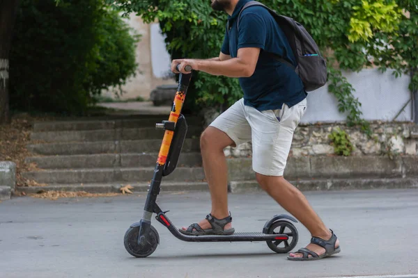 Jovem de férias se divertindo dirigindo scooter elétrico pela cidade no parque no verão — Fotografia de Stock