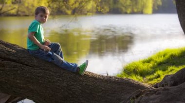 jongen zitten in de buurt van het water
