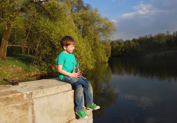 The boy on the river drinking water — Stock Photo, Image