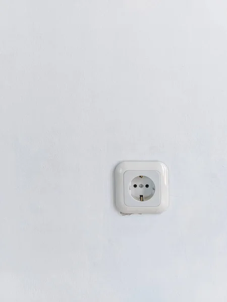 white electric power plug on a slightly white wall