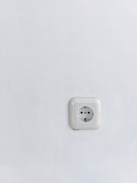 white electric power plug on a slightly white wall