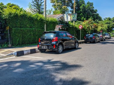 Otoyolun kenarına park edilmiş bir arabanın ofis bahçesinin önündeki görüntüsü.