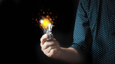 Ampulleri tutan adam, yenilikçi teknoloji ve yaratıcılık içeren yeni fikirler. Işıldayan ampullerle yaratıcılık kavramı.