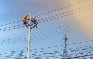 Elektrik direği tamircisi elektrik direği üzerinde çalışıyor..