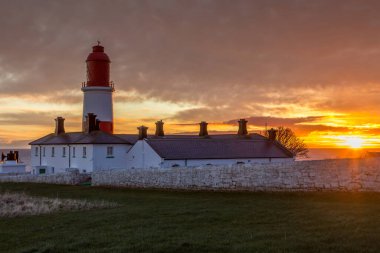 Kırmızı ve beyaz çizgili, 23 metre boyunda, Souter Lighthouse ve Leas in Marsden, South Shields, İngiltere, güneş doğarken