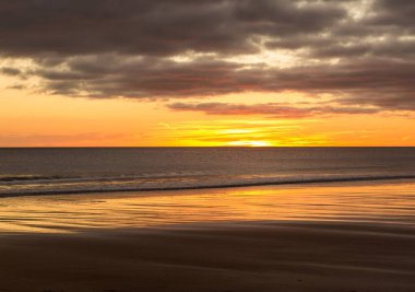 Gün doğumu Northumberland 'daki Blyth plajında başlıyor. St. Mary Deniz Feneri de uzakta.