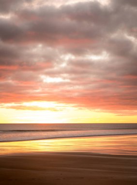 Gün doğumu Northumberland 'daki Blyth plajında başlıyor. St. Mary Deniz Feneri de uzakta.