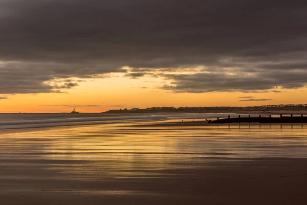 stock image Sunrise to start the day at Blyth beach in Northumberland, with St Mary's Lighthouse in the distance