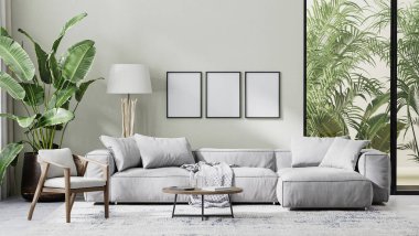 poster çerçevesi modern oturma odasının içini gri kanepe, ahşap mobilya ve palmiye yapraklarıyla süslüyor.