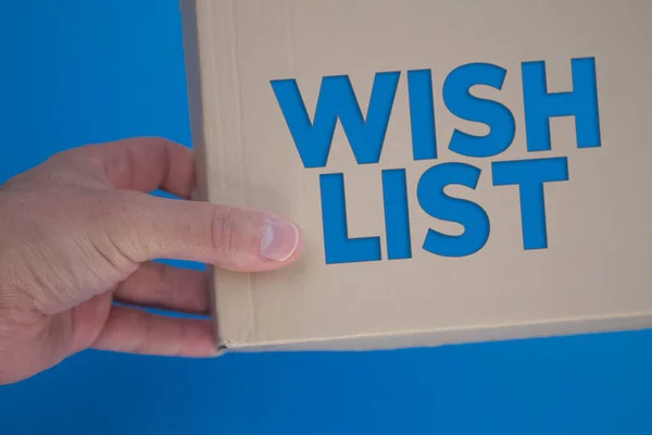 Wish List word with cardboard box. Brown folded cardbox.