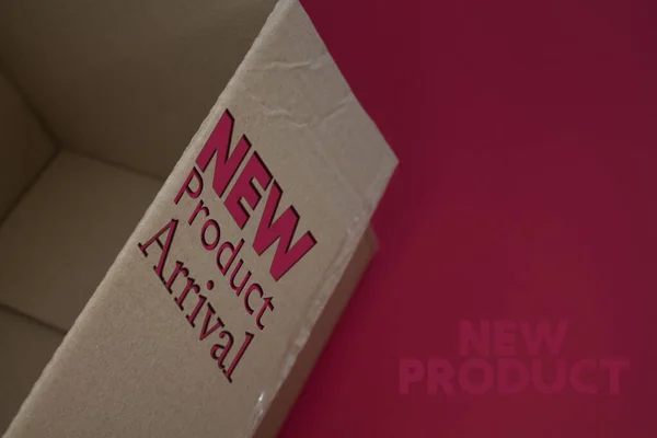 New Product Arrival word with cardboard box. Brown folded cardbox.