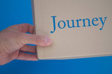 Karton kutuyla seyahat kelimesi. Kahverengi katlanmış kart kutusu.