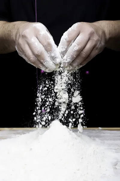 Mãos deixando cair farinha — Fotografia de Stock