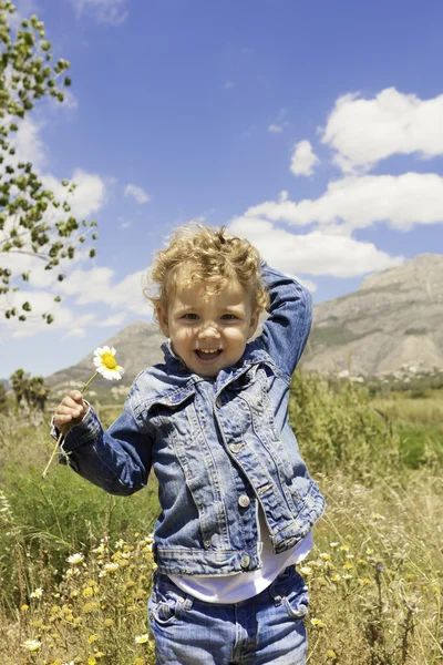 Niño con flor en el campo —  Fotos de Stock