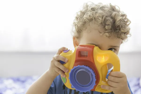 Niño jugando con una cámara de fotos de juguete —  Fotos de Stock