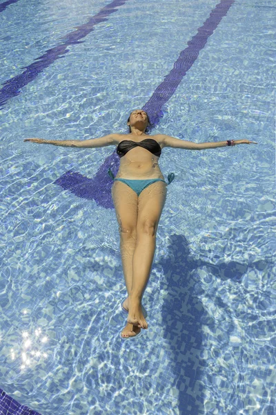Νεαρή γυναίκα που επιπλέουν στην πισίνα — Φωτογραφία Αρχείου
