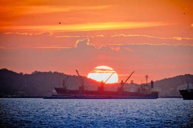 Yük gemisi, açık deniz operasyonunda nakliye alanında büyük gün batımında kargo mavnalarıyla birlikte, Tayland 'ın Koh sichang limanında kargo boşaltıyordu. 