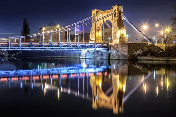 古桥和夜间照明的城市 — 图库照片