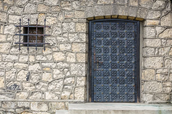 Stone wall texture and ancient door and small window — Stock Photo, Image