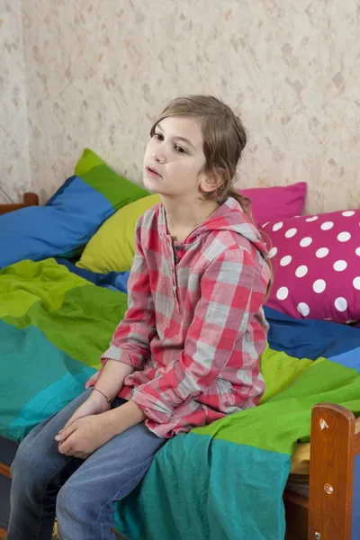 Nieszczęśliwa dziewczynka siedzi na łóżku. Problemy z rodzicami — Zdjęcie stockowe