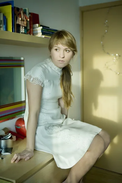 Porträt eines nachdenklichen jungen Mädchens, das auf dem Tisch sitzt. Erstes Ziel — Stockfoto