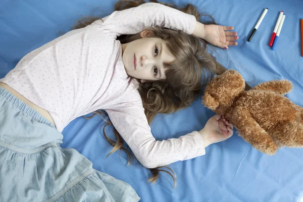 Roztomilá dívka leží na posteli — Stock fotografie