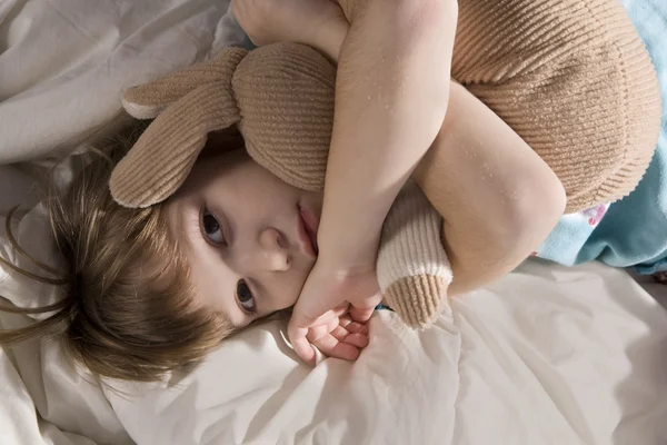 Niña con oso en el sofá — Foto de Stock