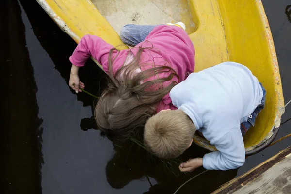 Friendship. Children playing in yellow boat. Summer time — Stock Photo, Image