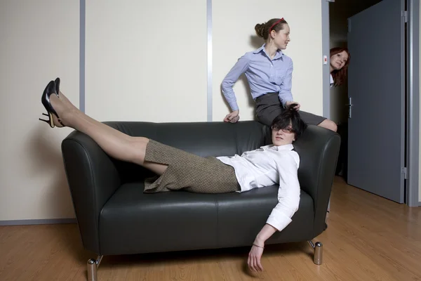 Tired boss lying on sofa. Secretary try to do  massage — Stock Photo, Image