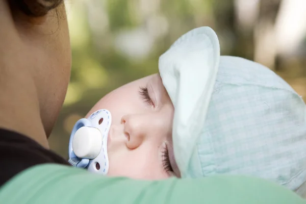 One-year-old baby sleeping on shoulder of mother — Stock Photo, Image
