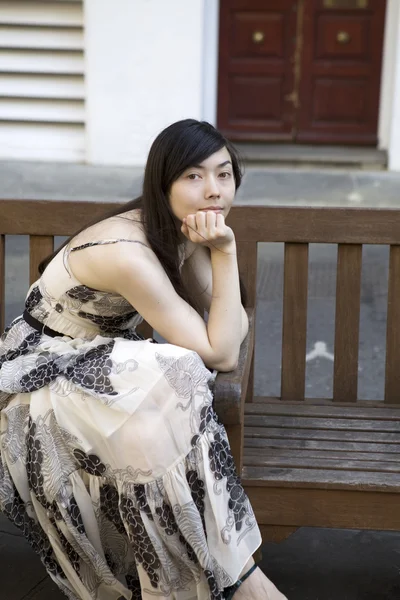 Pensive woman sitting on bench — Stock Photo, Image