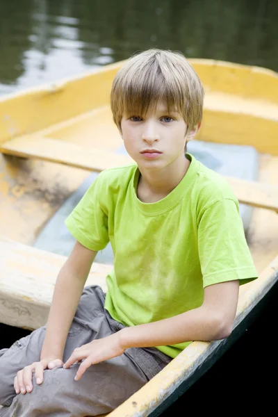 Little cute serious boy sitting in boat — Stock Photo, Image
