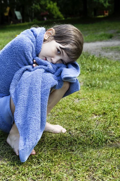 Klein schattig meisje, zittend op de oever van rivier — Stockfoto