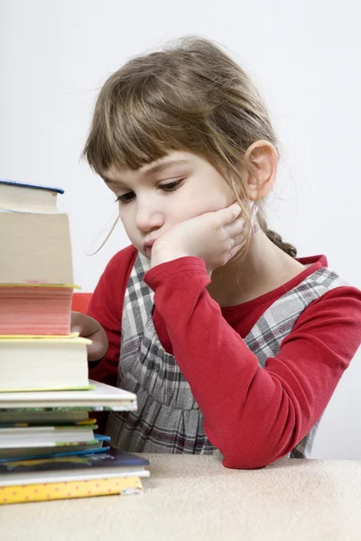 Trauriges Mädchen mit einem Stapel Buch — Stockfoto